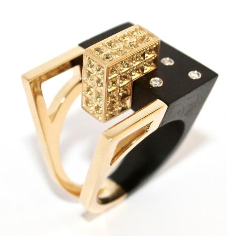 Anello Urban Contact, ebano e oro 18 kt rivestito di zaffiri gialli e diamanti incastonati - La contaminazione tra il pregiato  Ebano e il prezioso Oro 18 kt, rivestito  di Zaffiri gialli, simboleggia l’armonia  delle moderne costruzioni dall’aspetto  austero ed elegante, inserite nel  green-mood circostante ridisegnato  dall’uomo sottoforma di accoglienti  giardini dove la natura si risveglia nei preziosi Diamanti incastonati.